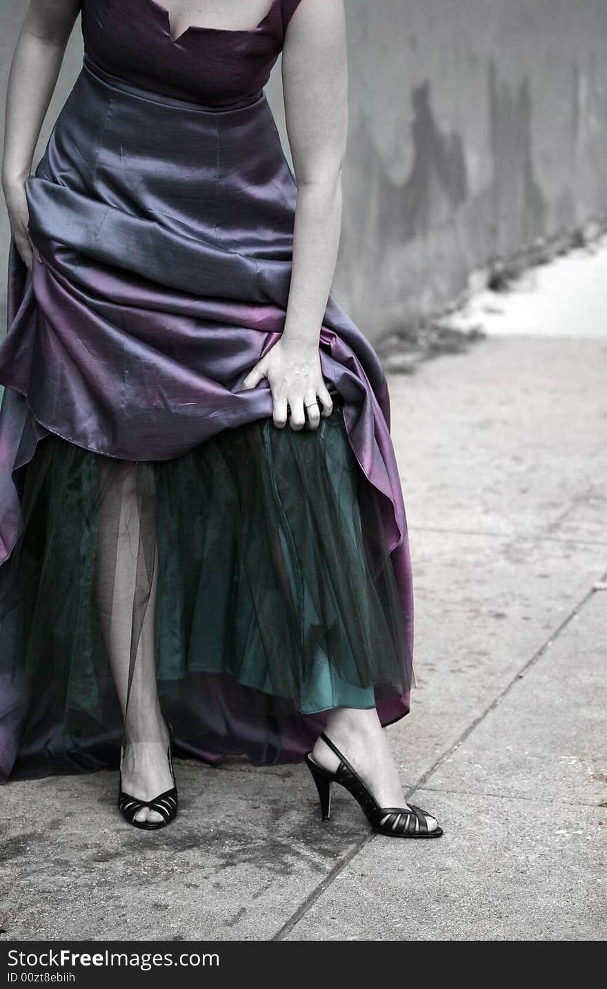 A colorized image of a woman wearing an evening gown in the city. A colorized image of a woman wearing an evening gown in the city