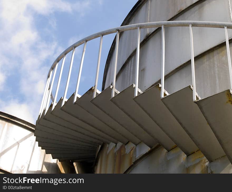 Spiral staircase up a industrial cylindrical tank to access its roof. Spiral staircase up a industrial cylindrical tank to access its roof