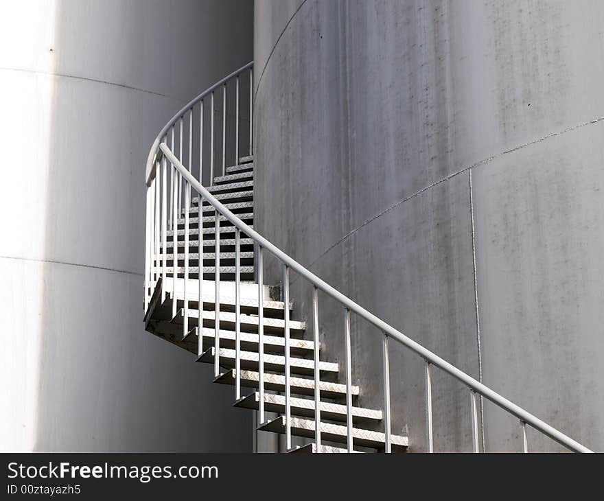 Spiral staircase up a industrial cylindrical tank to access its roof. Spiral staircase up a industrial cylindrical tank to access its roof