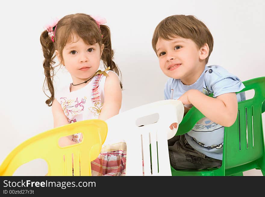 Adorable children sitting on colorful chairs