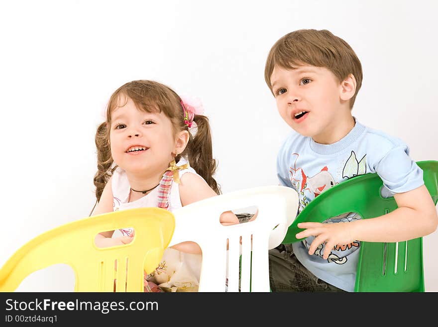 Adorable children sitting on colorful chairs