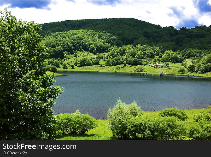 A view of mountain landscape with a small lake. A view of mountain landscape with a small lake