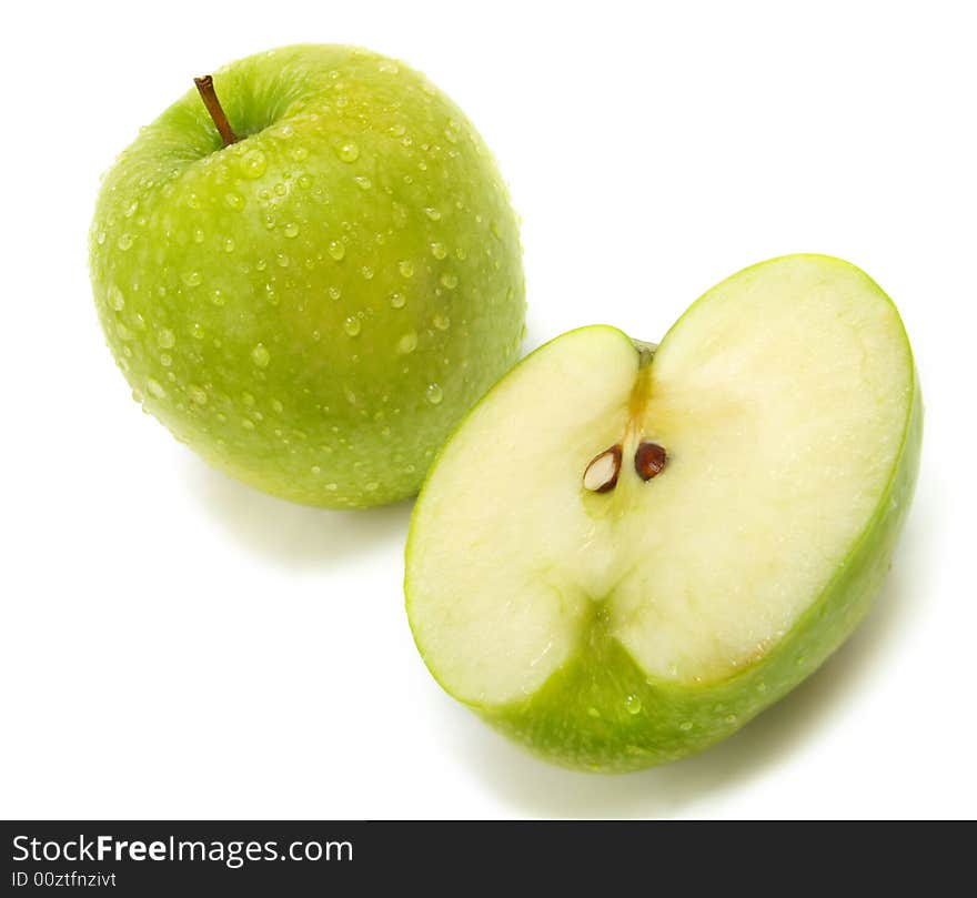 A half and a whole fresh ripe green apple with water drops isolated on white background. A half and a whole fresh ripe green apple with water drops isolated on white background