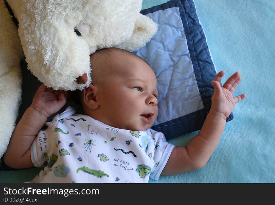 Week old baby boy on a blue blanket early in the morning. Week old baby boy on a blue blanket early in the morning