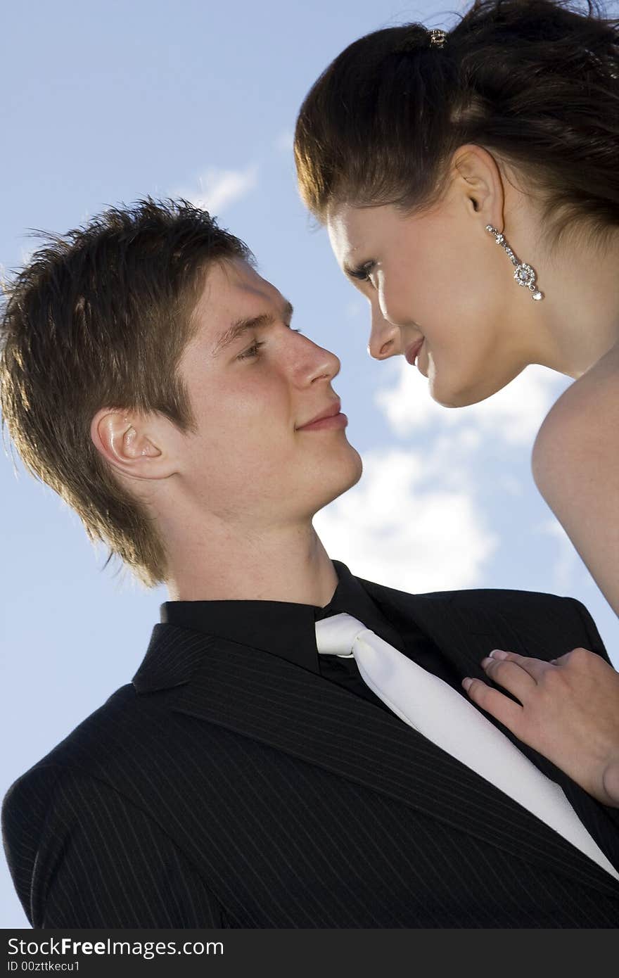 Young beautiful happy couple on sky background. Young beautiful happy couple on sky background