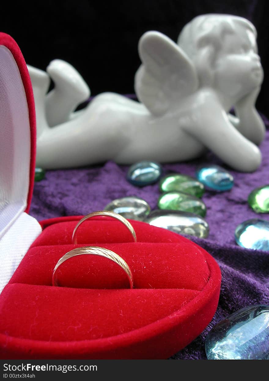 Wedding rings in red box with an angel