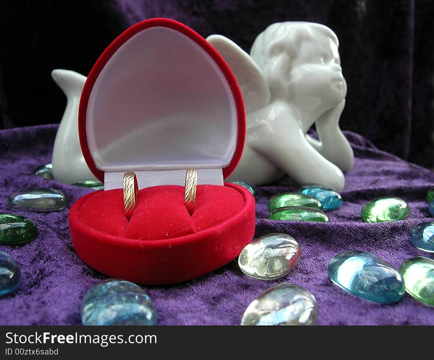 Wedding rings in red box with an angel