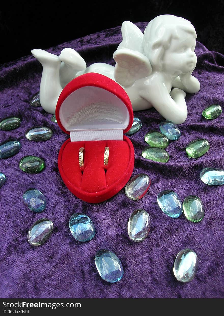 Wedding rings in red box with an angel