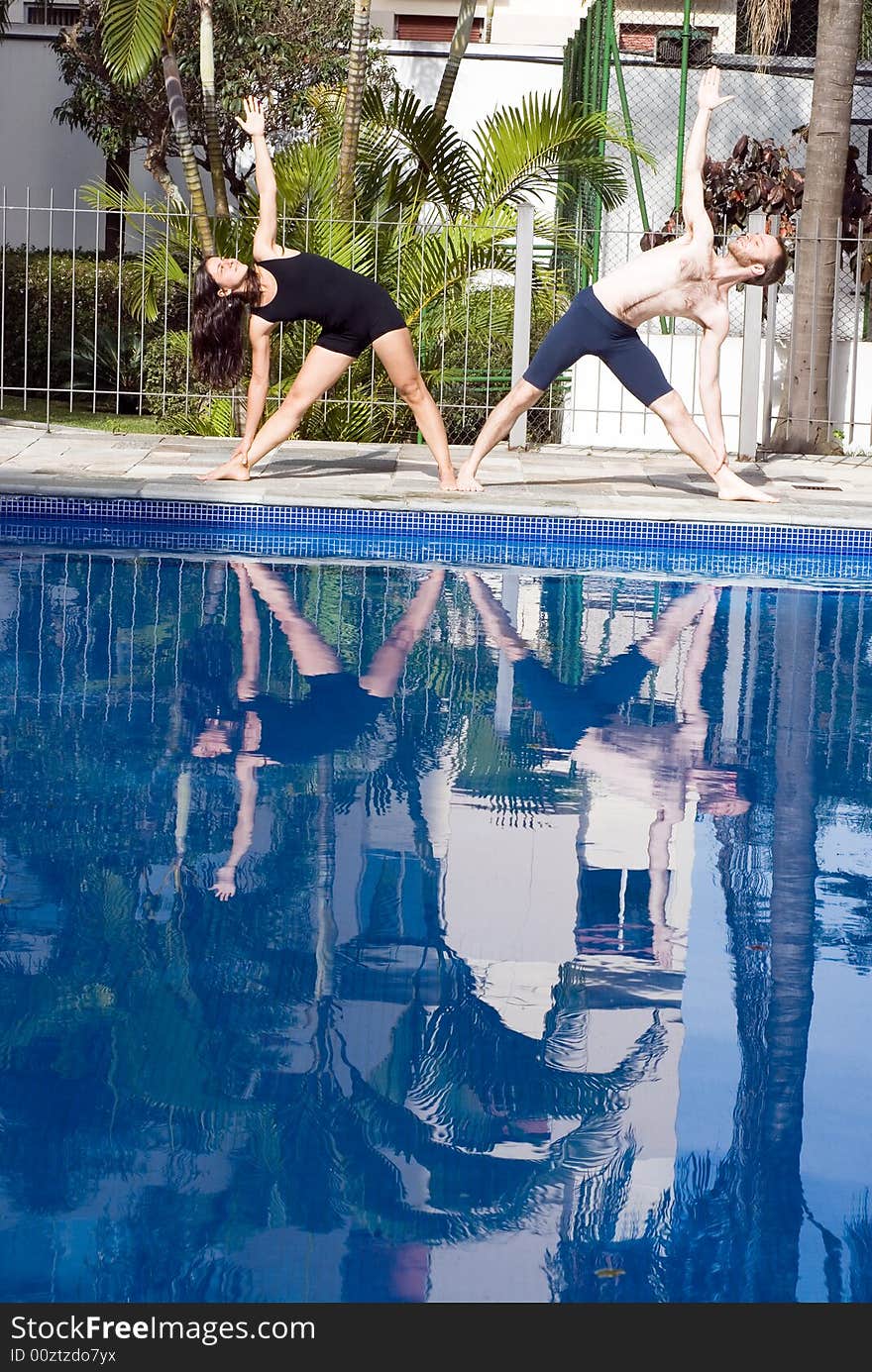 Couple Stretching Side at Poolside - vertical