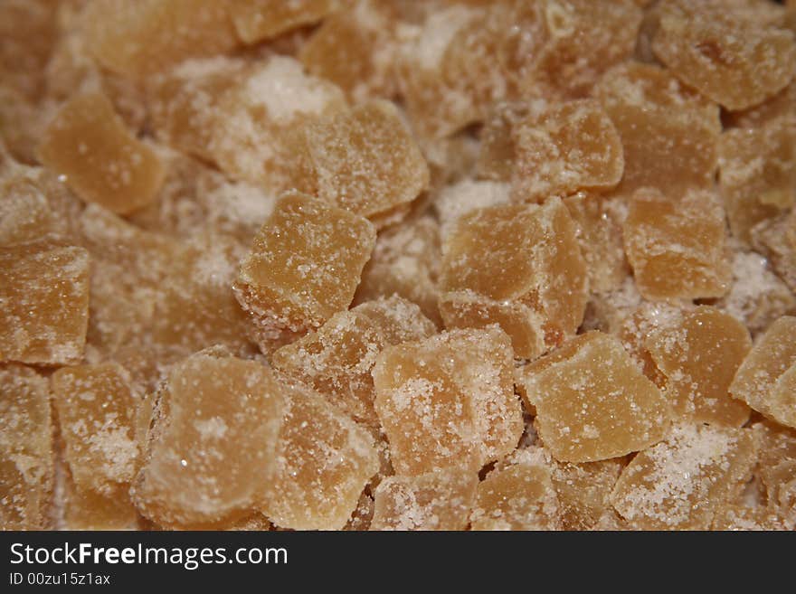 Pieces of crystallized ginger covered in sugar. Pieces of crystallized ginger covered in sugar