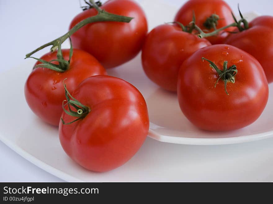 Red tomatoes on the white square dishes