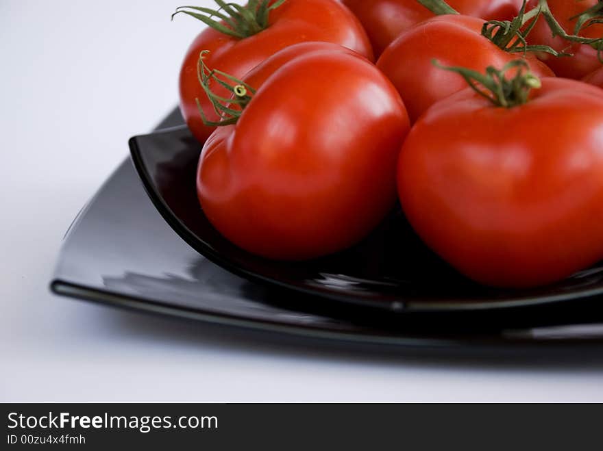 Red tomatoes on the black square dishes