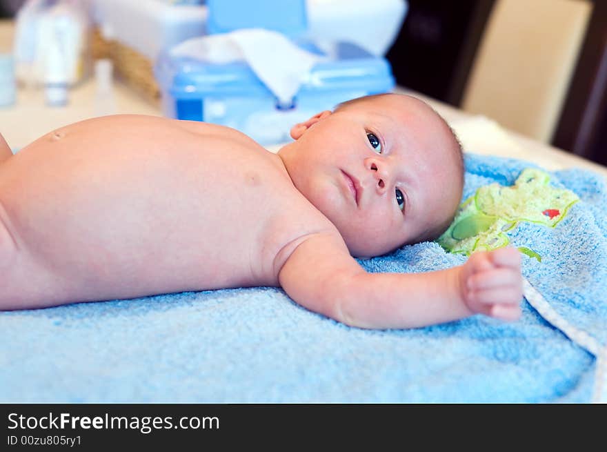 Five weeks thoughtful baby lying on bathing towel. Five weeks thoughtful baby lying on bathing towel