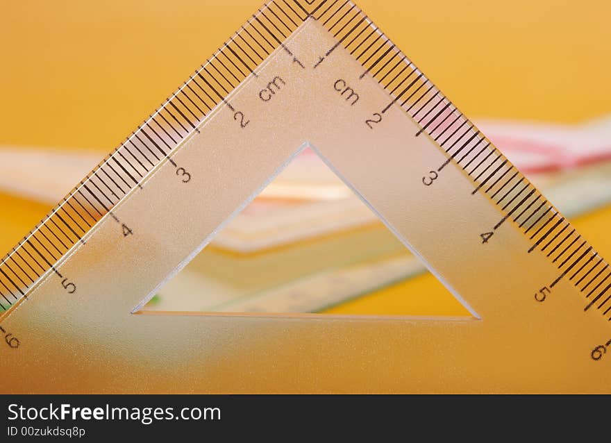 Geometric rulers on top of yellow colored paper