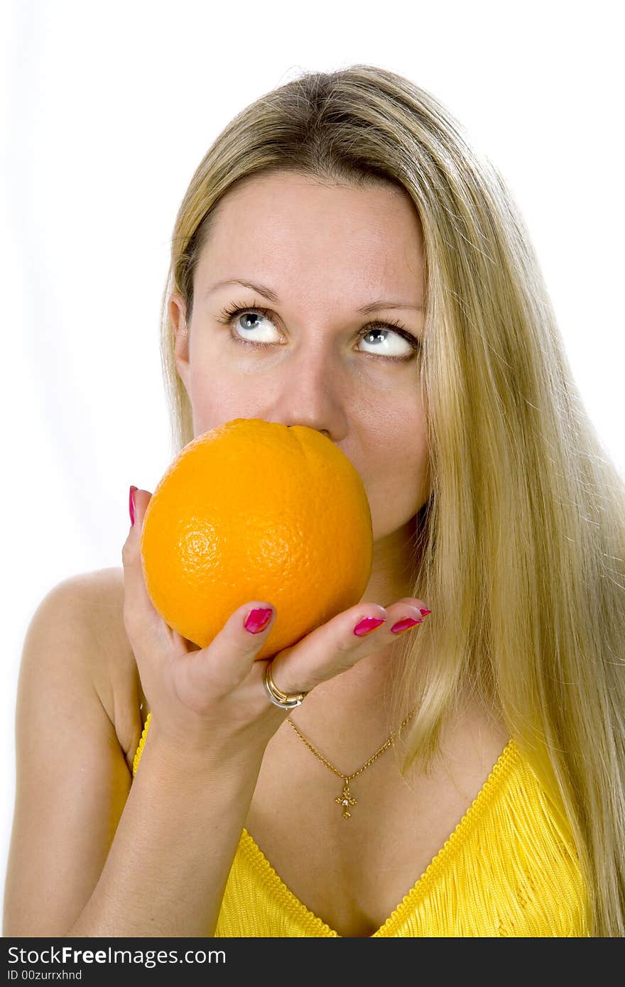 Blonde woman in yellow dress with orange in her hands. Blonde woman in yellow dress with orange in her hands