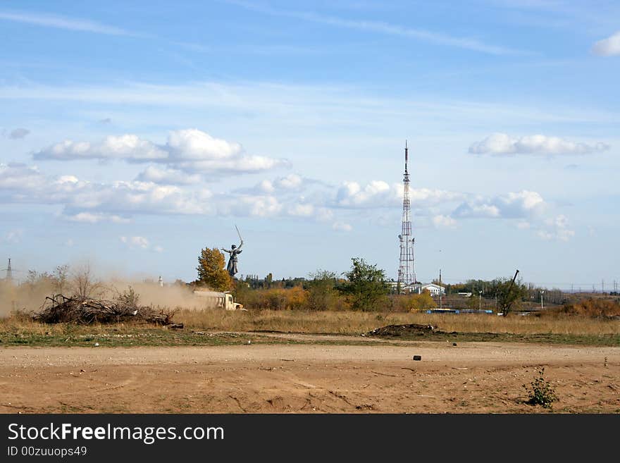 Television antenna and field on background blue sky and clouds