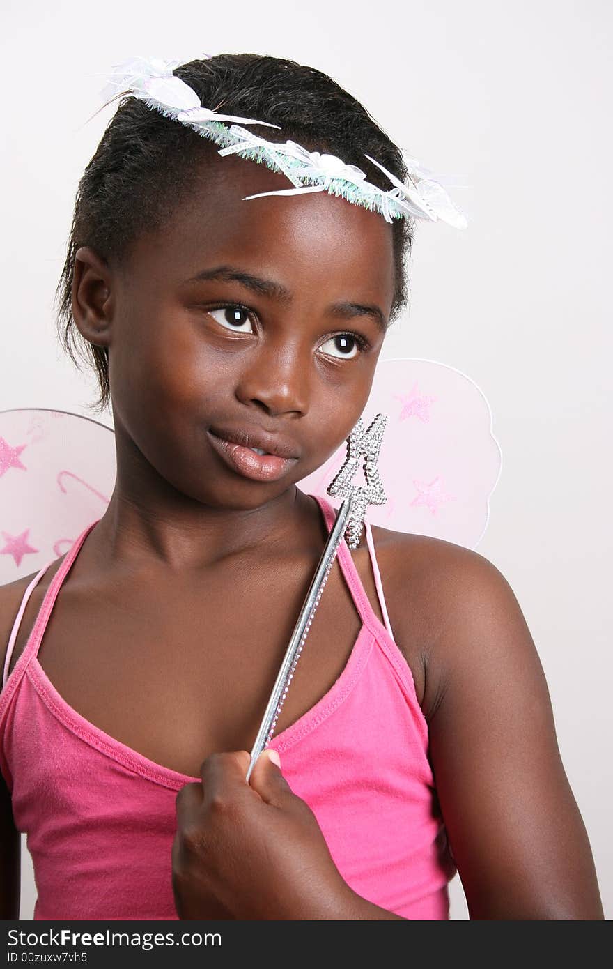 Young girl wearing a pink fairy costume with accessories