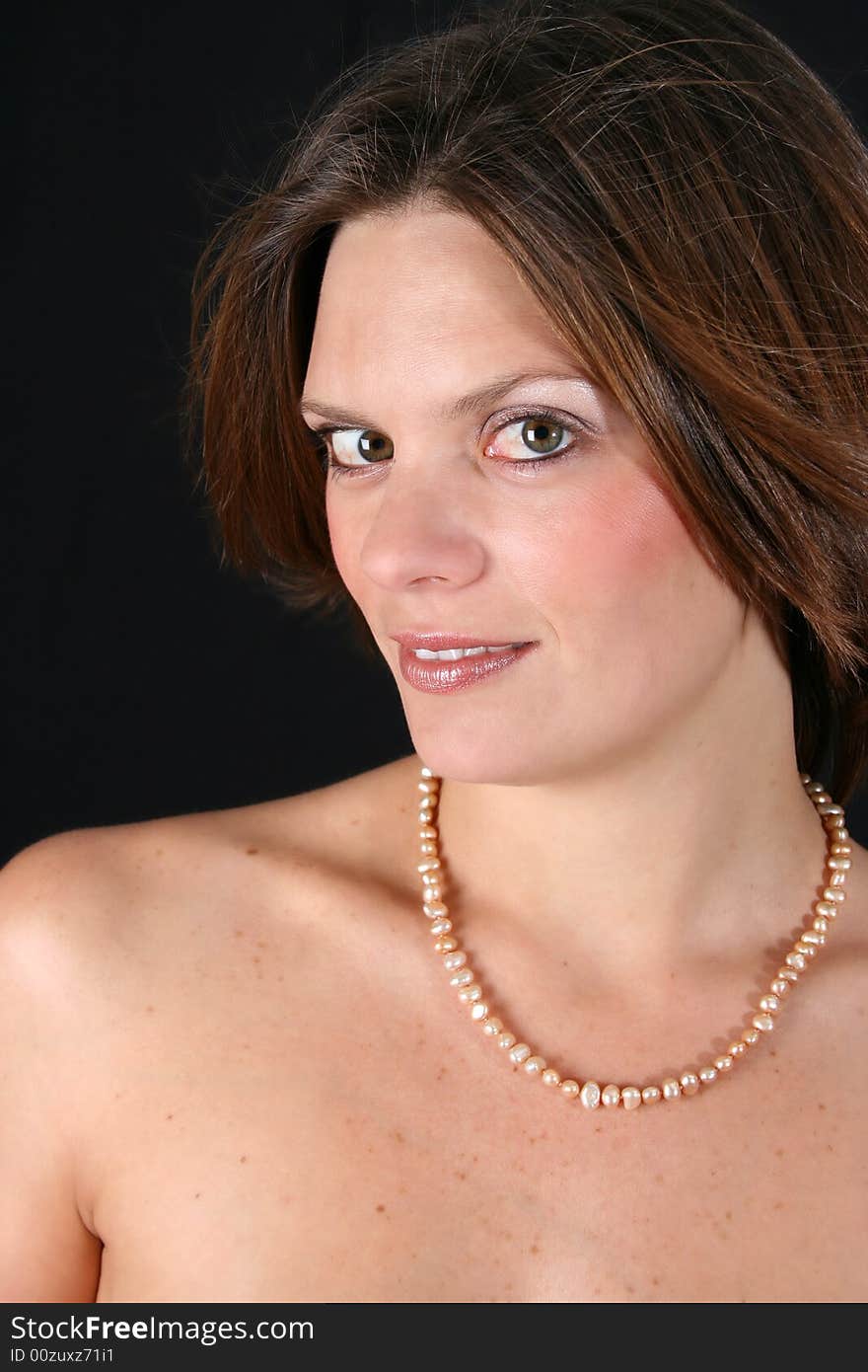 Beautiful young woman with bare shoulders and pearls. Beautiful young woman with bare shoulders and pearls