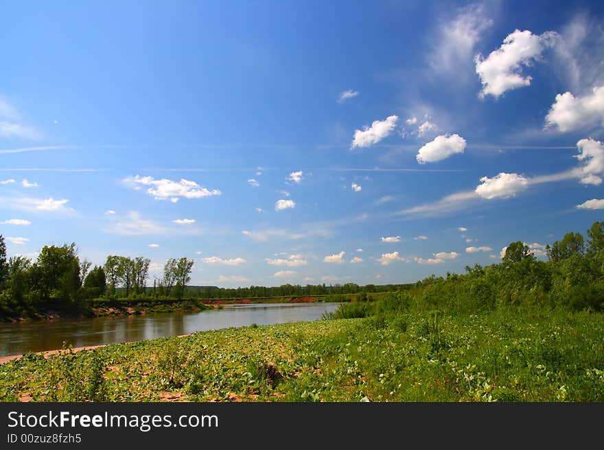 Summer landscape with river under blue sky