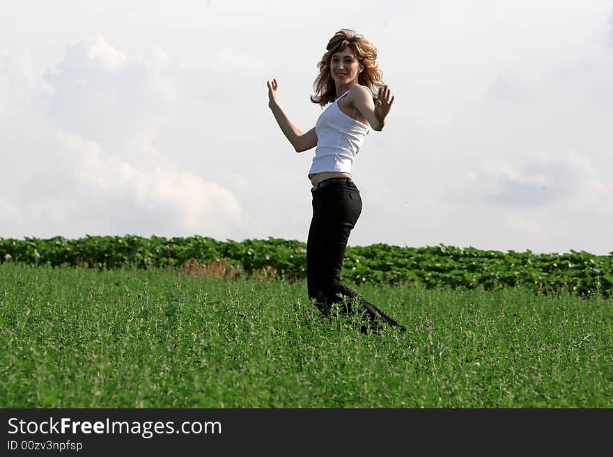 A beautiful girl jumping on the field