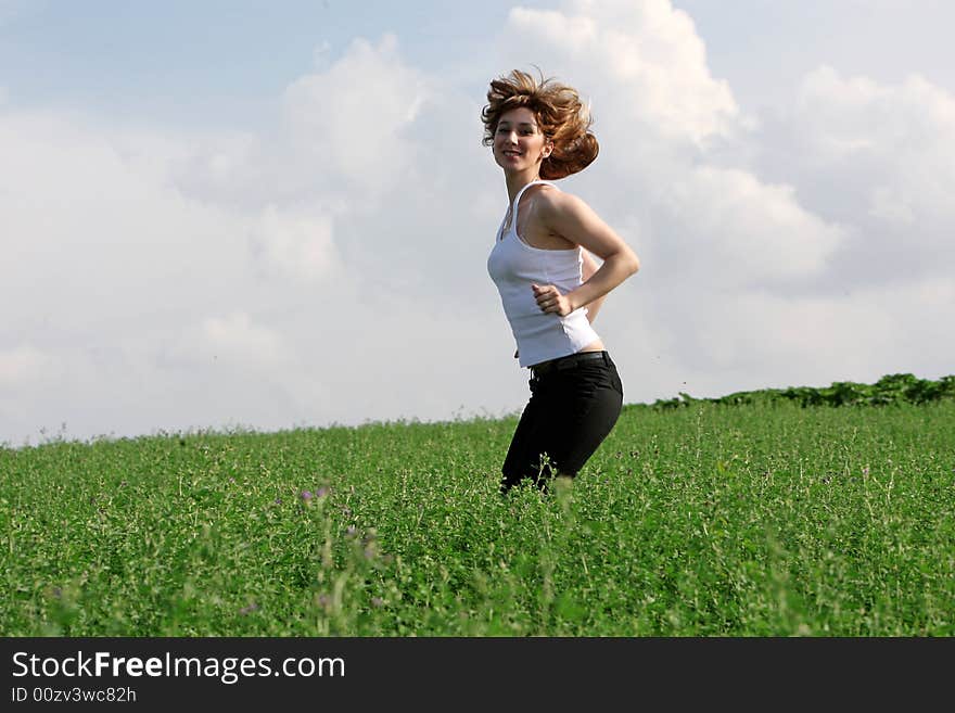 A beautiful girl jumping on the field