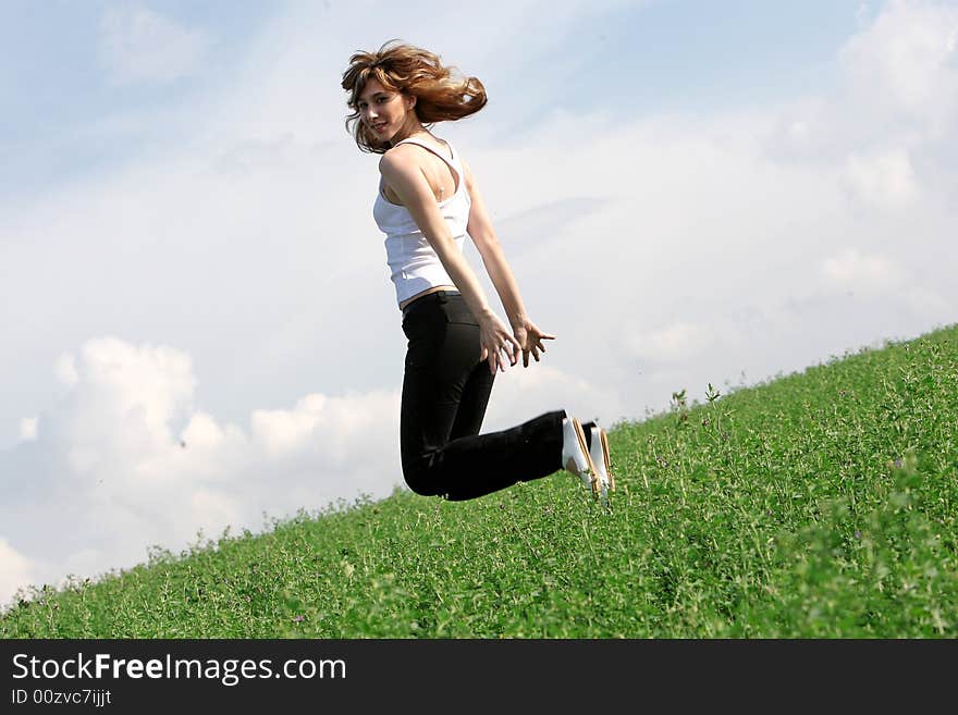 A beautiful girl jumping on the field