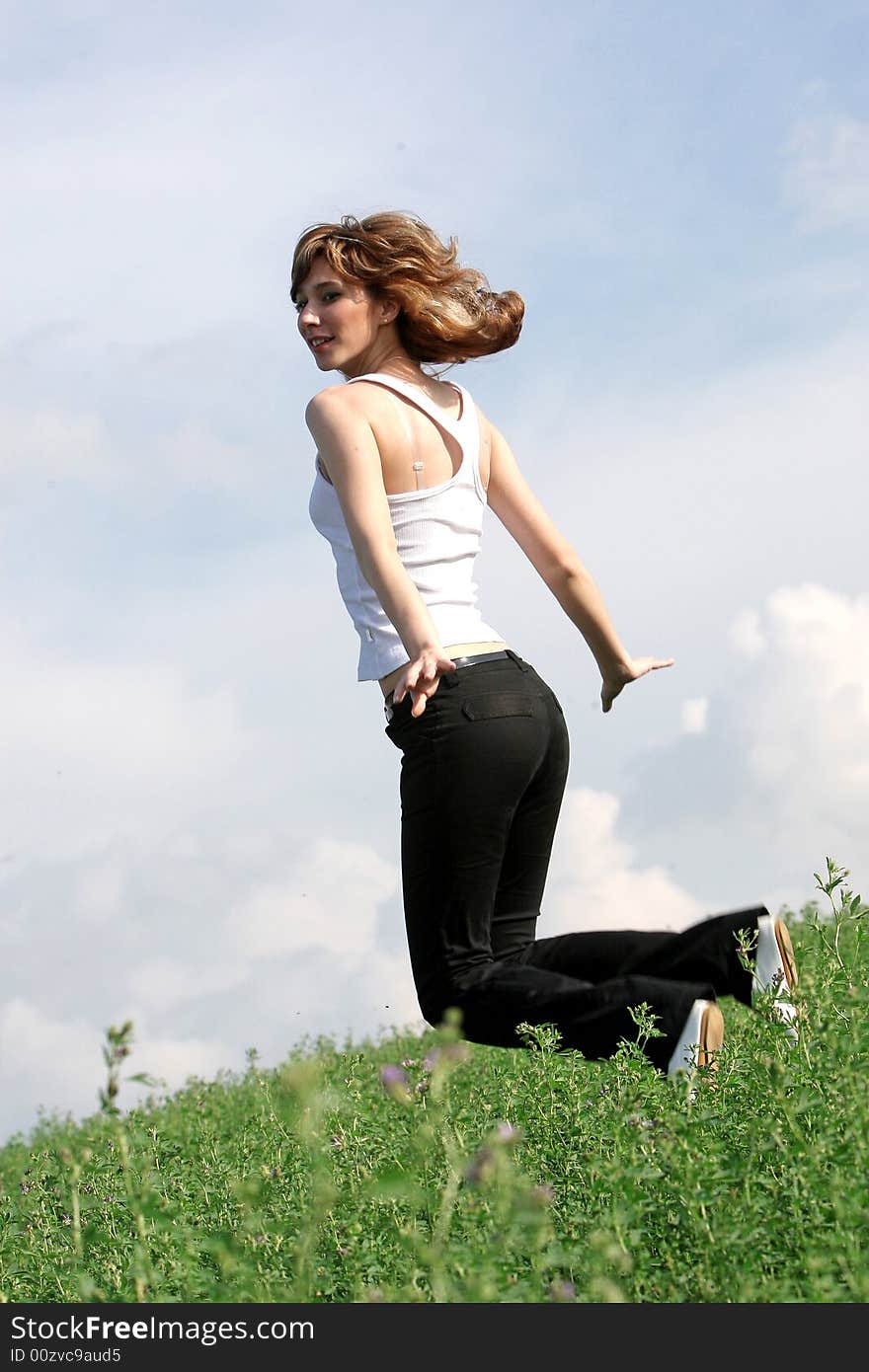 A beautiful girl jumping on the field