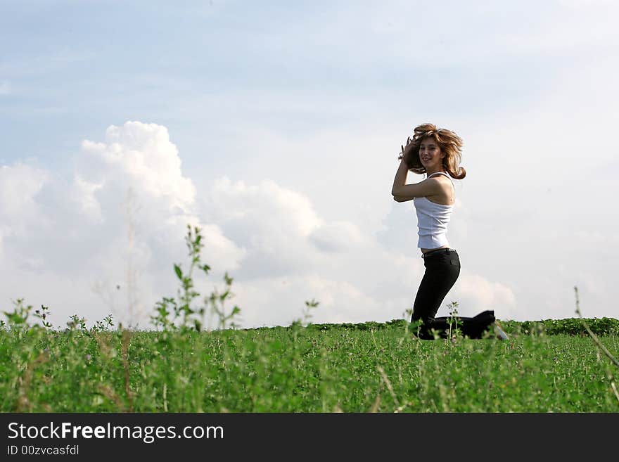 A beautiful girl jumping on the field