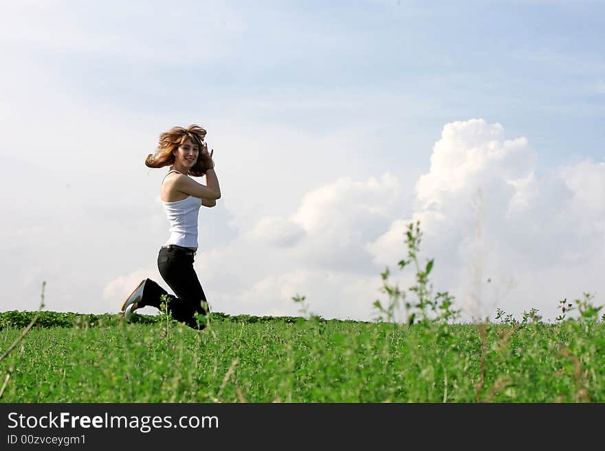 A beautiful girl jumping on the field