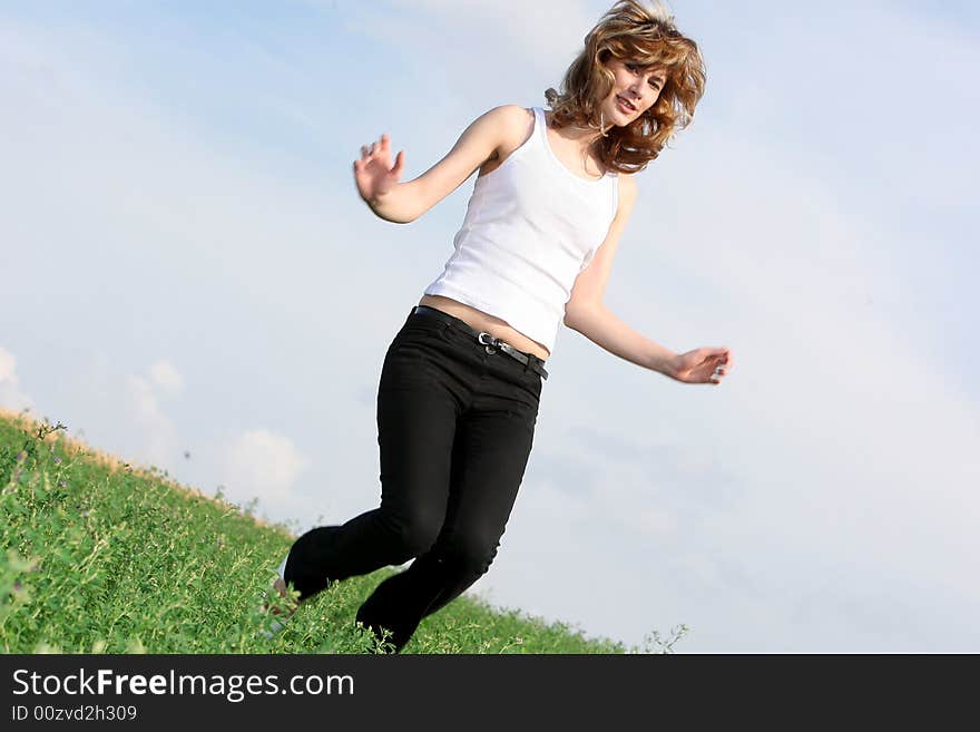 A beautiful girl jumping on the field