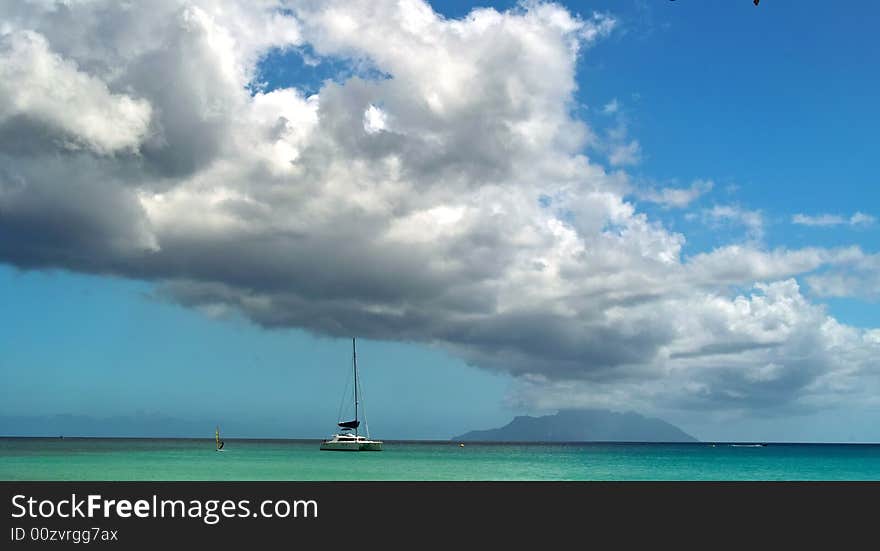 Catamaran boat is arriving to the tropical island . 
The sea , sky and clouds as background. Catamaran boat is arriving to the tropical island . 
The sea , sky and clouds as background.