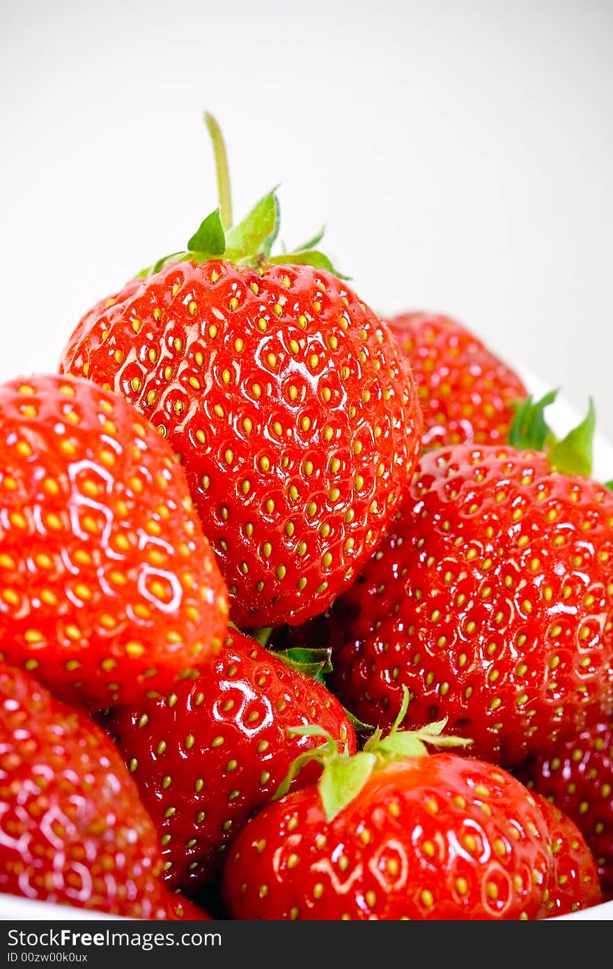 Some delicious strawberries in a white bowl whit white background