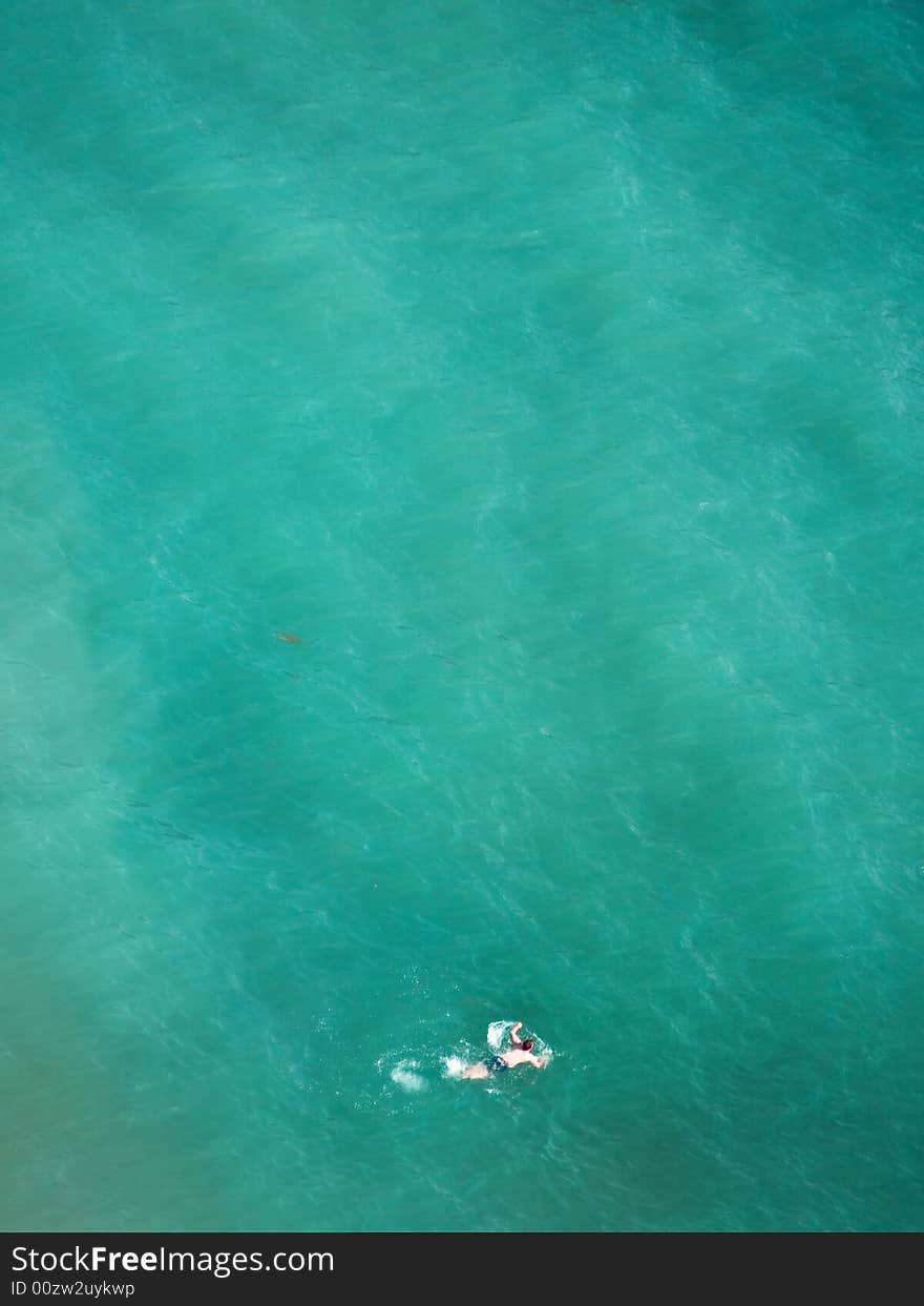 Lonely swimmer on tropical blue water. Lonely swimmer on tropical blue water