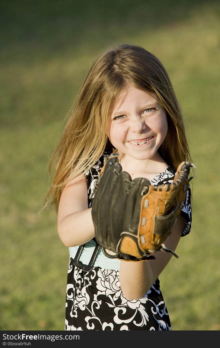 Cute young girl in summer dress with a baseball. Cute young girl in summer dress with a baseball