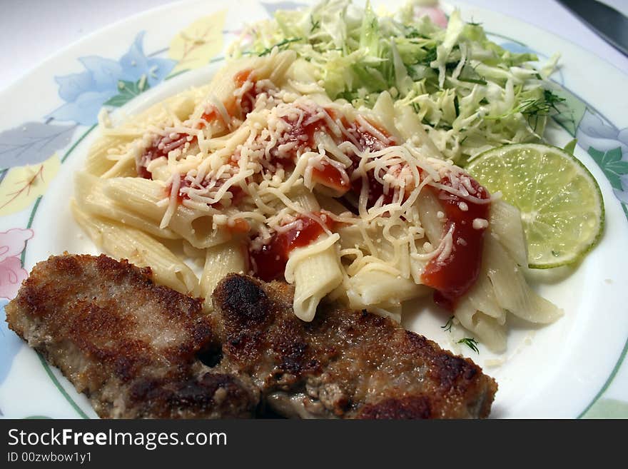 Pork chops with the pasta strewed by parmesan, and cabbage salad