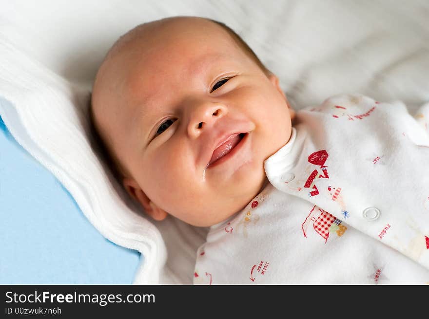 Six week baby lying on diaper. Baby is smiling straight at camera. Six week baby lying on diaper. Baby is smiling straight at camera.