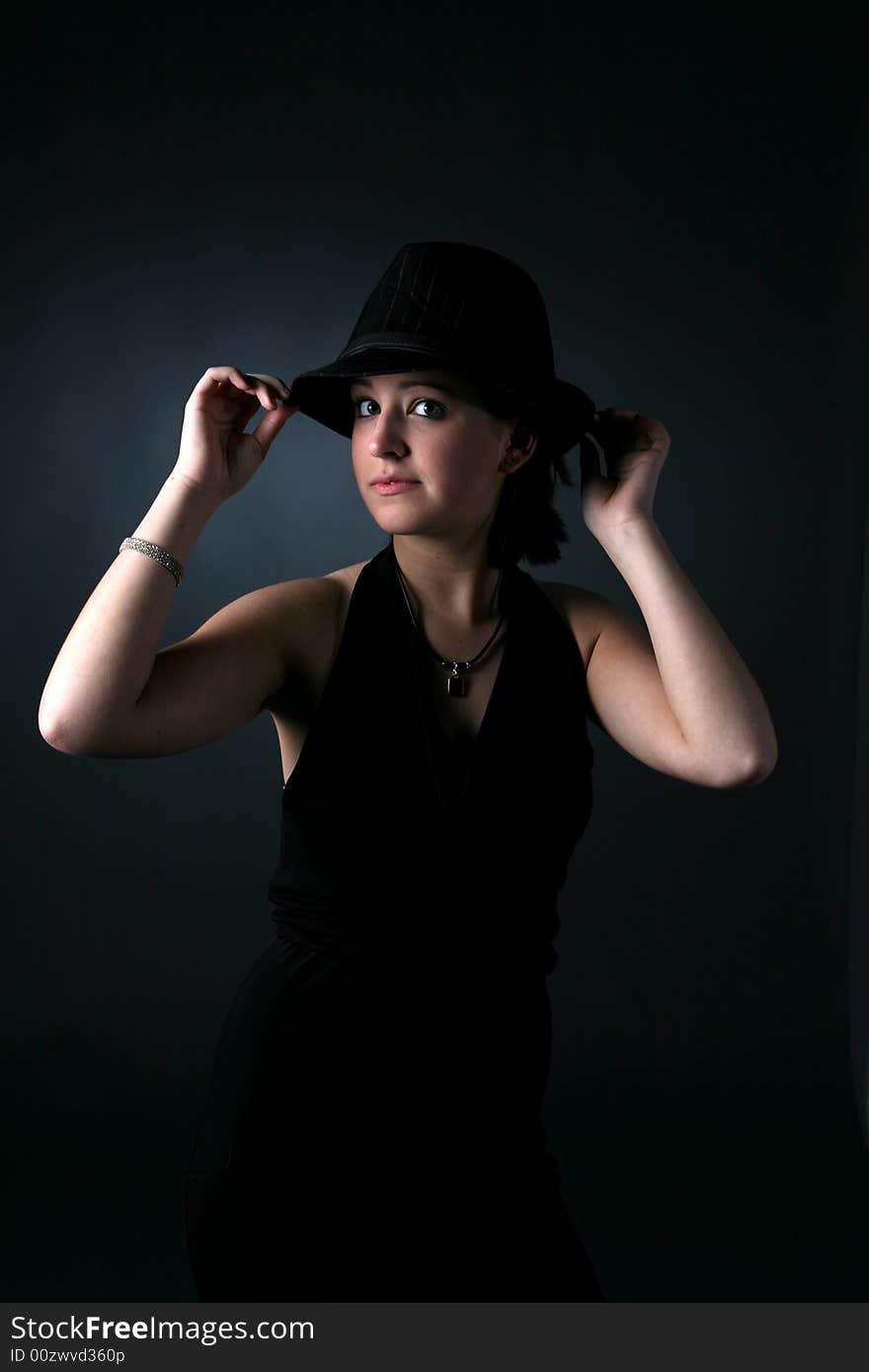 Teenage girl in top hat with dramatic lighting. Teenage girl in top hat with dramatic lighting