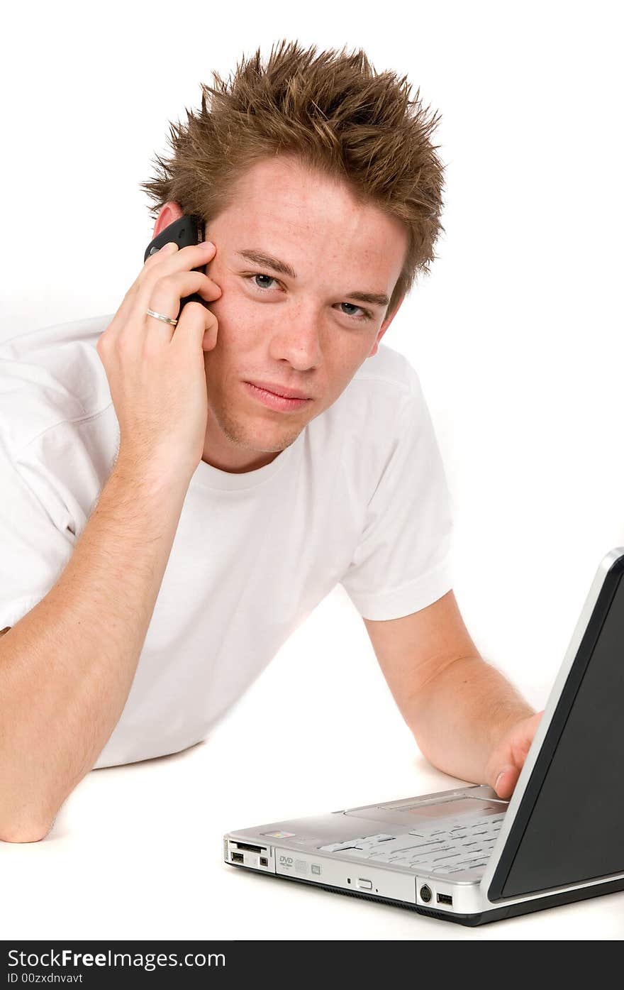 A young man multitasking on the phone and computer