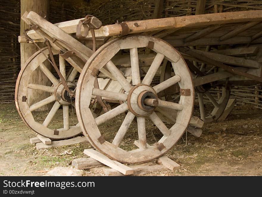 The old wooden cart costing under a canopy. The old wooden cart costing under a canopy.