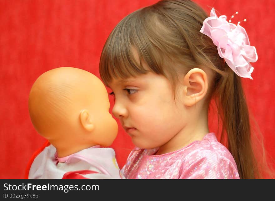 The little girl looks at the favorite doll. The little girl looks at the favorite doll