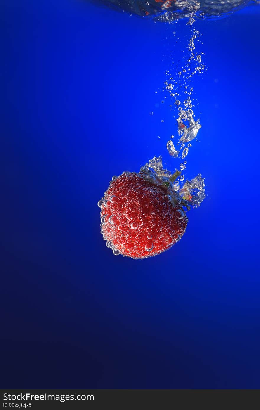 Strawberry in water. A falling berry in cold water.