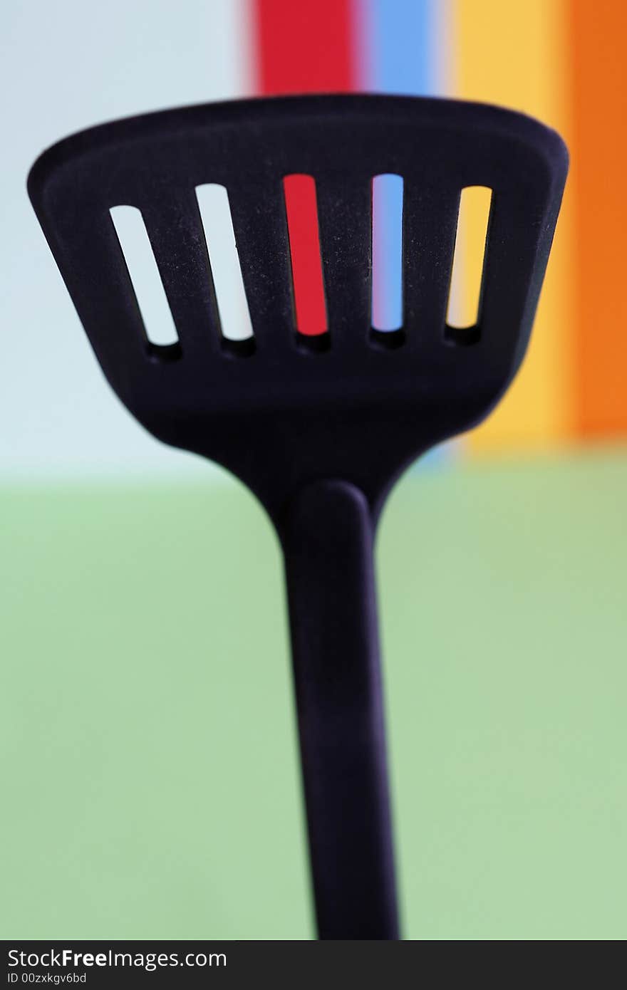 A big spoon with holes in a simple colorful background. A big spoon with holes in a simple colorful background