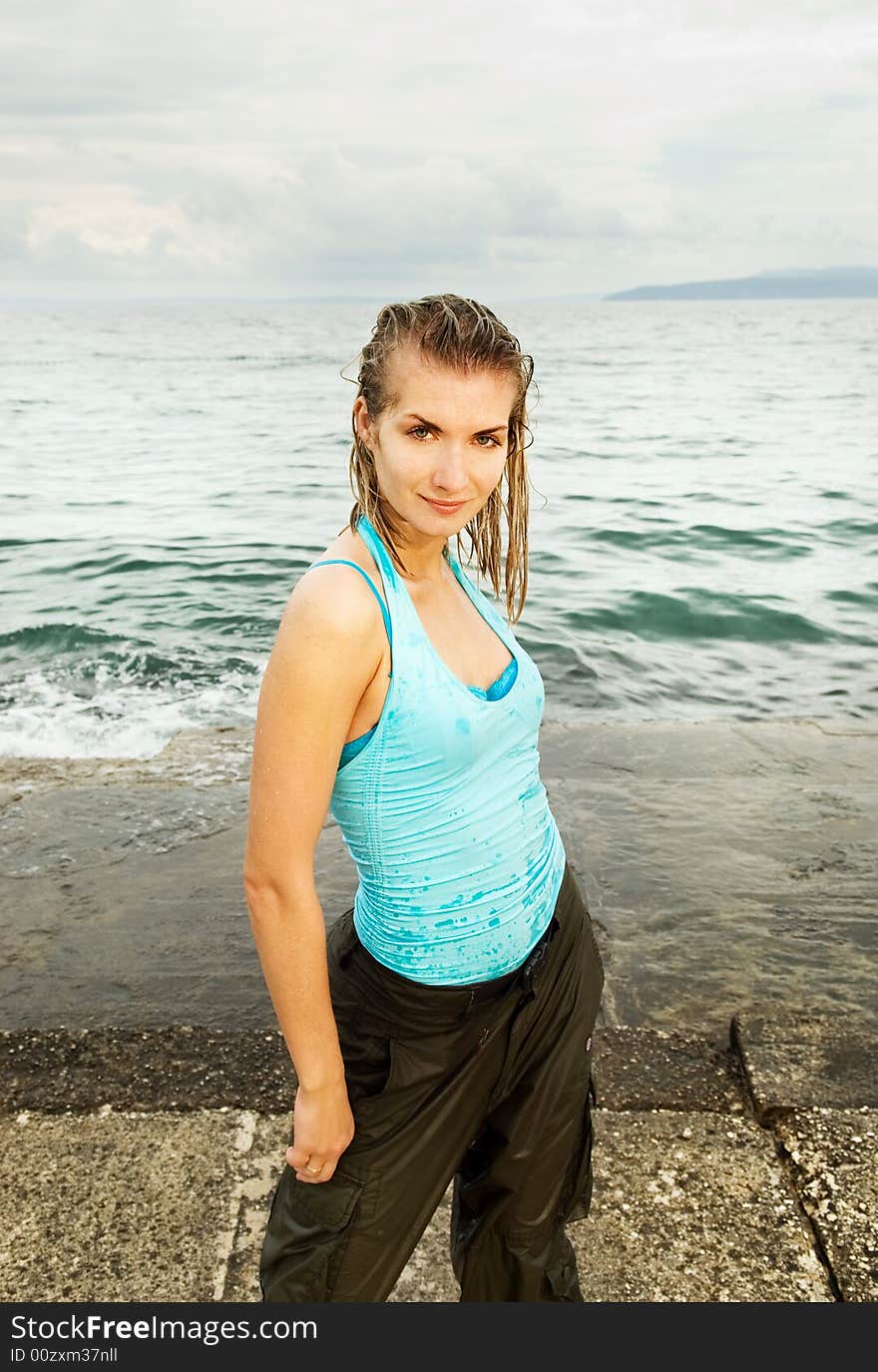 Wet girl standing near the ocean