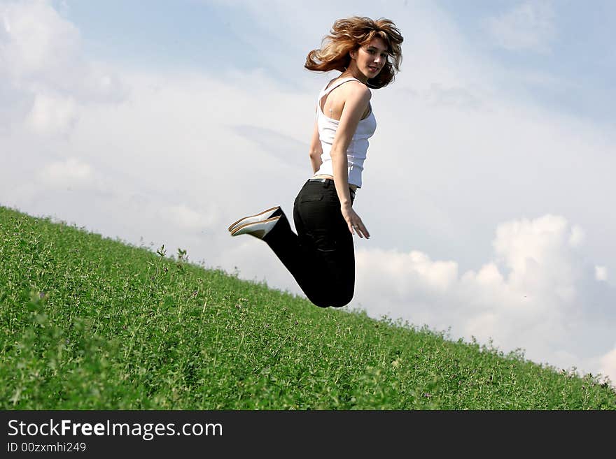 A beautiful girl jumping on the field