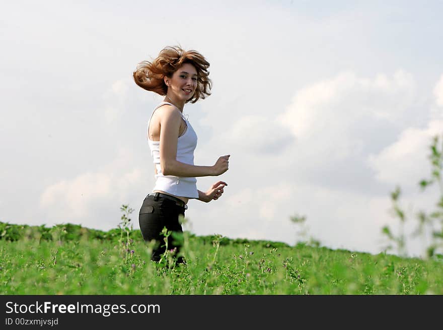 A beautiful girl running on the field. A beautiful girl running on the field