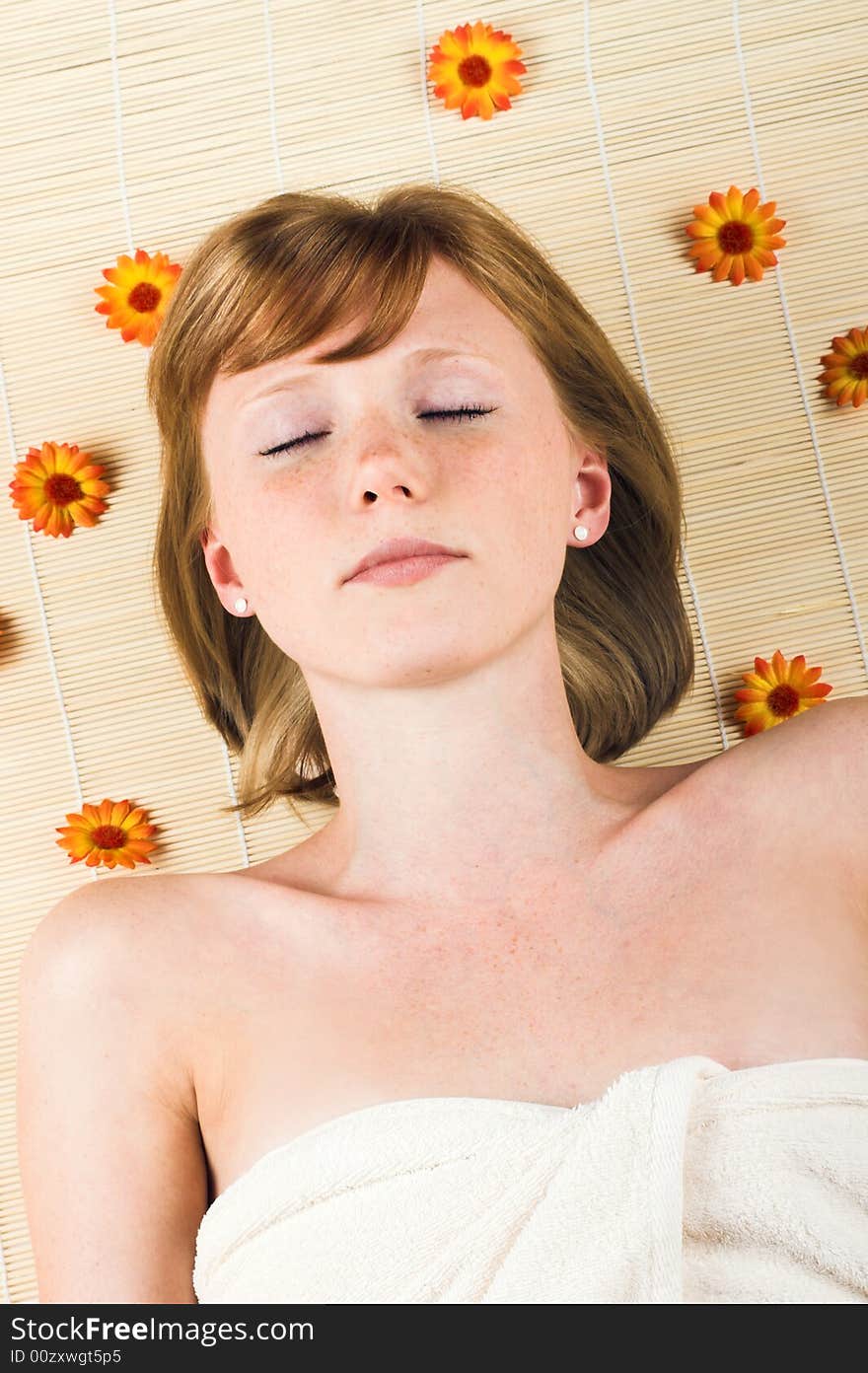 Young beautiful woman in a spa with a towel and flowers. Young beautiful woman in a spa with a towel and flowers