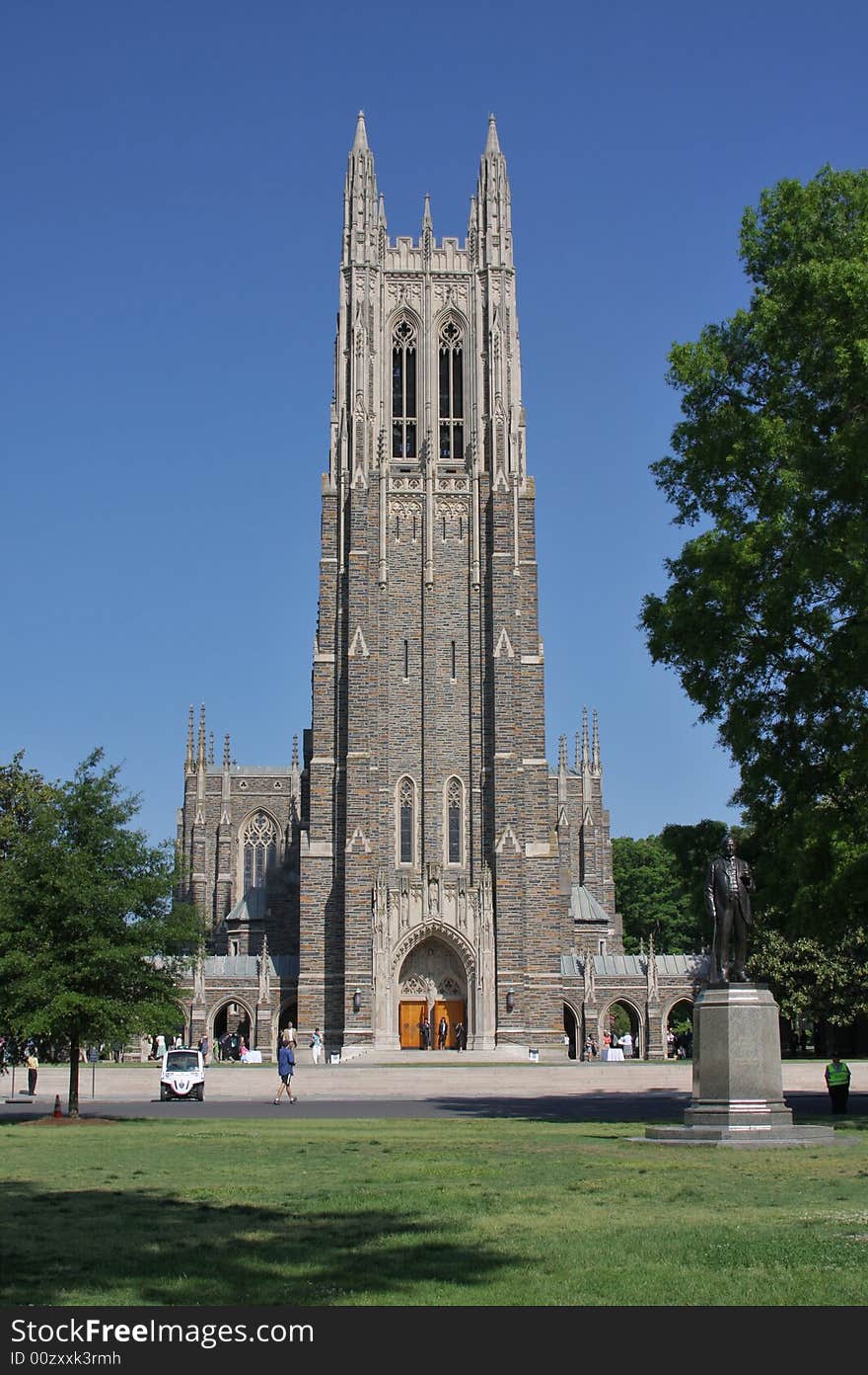 Cathedral tower against blue sky and green meadow