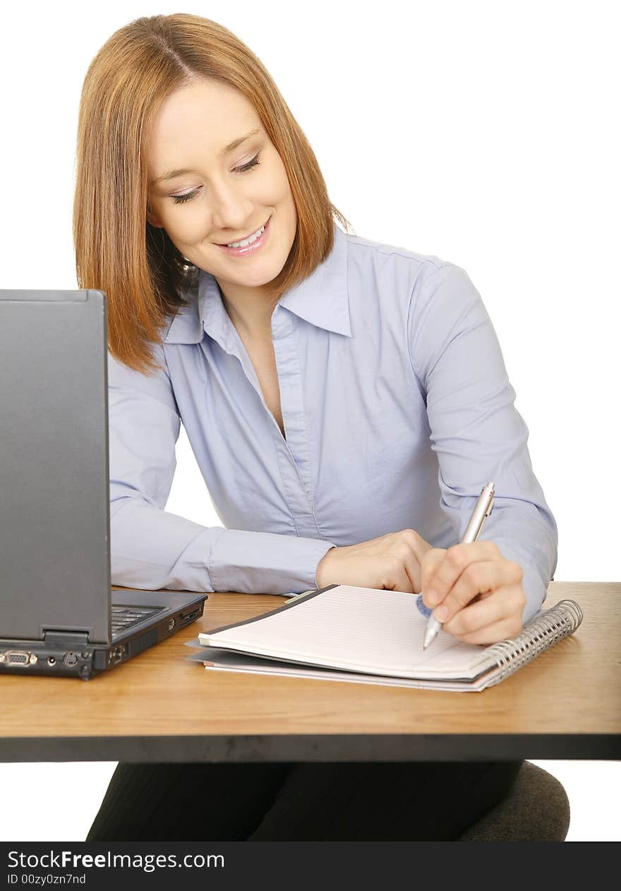 Young caucasian woman making note or writing on notepad, she is smiling. Young caucasian woman making note or writing on notepad, she is smiling