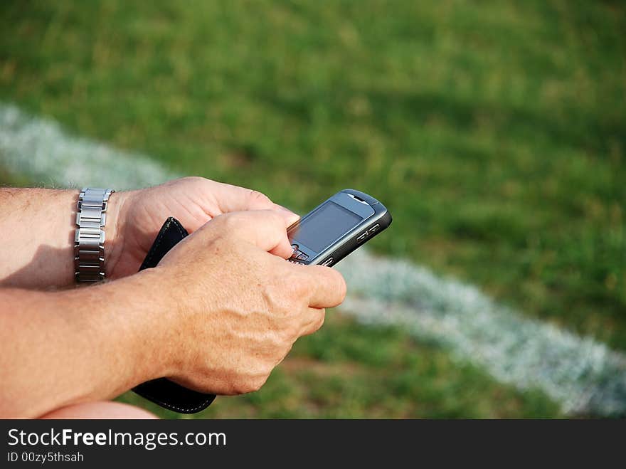 A business man sending e-mail during a soccer game. A business man sending e-mail during a soccer game.