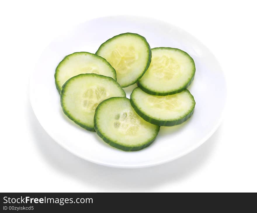 Fresh cucumber slices forming a circle on a white plate. Fresh cucumber slices forming a circle on a white plate